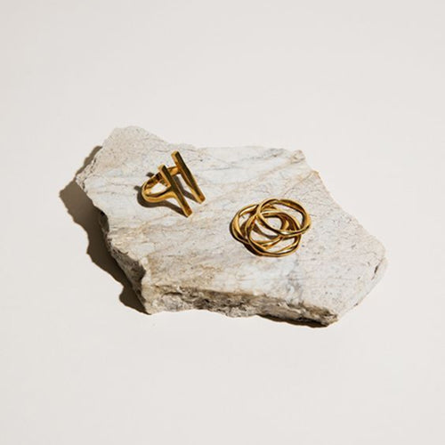 Gold rings on a piece of stone with a neutral background