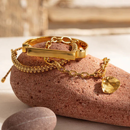 Gold bracelet with a heart charm on a pink stone